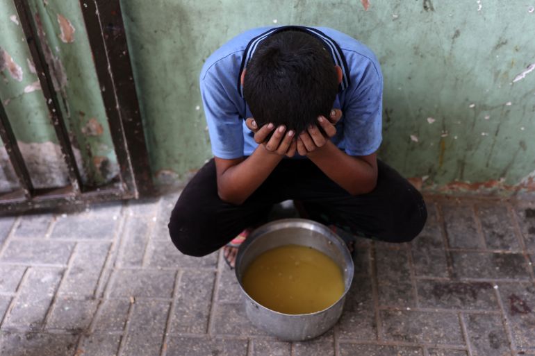 الأسبوع في صور 2 A displaced Palestinian child sits next to a pot of lentil soup that he received at a food distribution point in Gaza City in the northern Gaza Strip on July 25, 2025.