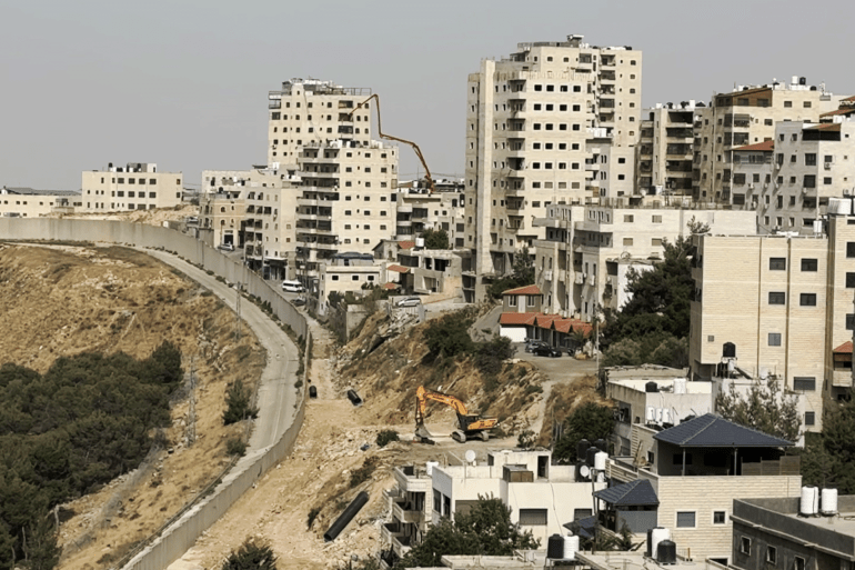 رئيس بلدية عناتا بالقدس: البلدة منكوبة والاحتلال صادر 90% من أراضيها 1 فلسطين - شمال شرق القدس - عناتا - 07.2025 - محمد السنجلاوي - خاص الجزيرة نت -(مشهد للجدار باقصى الجهة الشمالية لبلدة عناتا بحيث يفصل بين عناتا ومسوطنة النبي يعقوب )