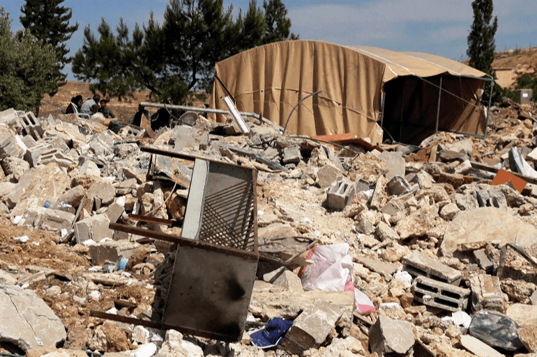 قادة الكنائس ودبلوماسيون يدينون عنف المستوطنين بالضفة 1 في جنوب الضفة الغربية فلسطينيون يتمسّكون بالبقاء رغم العنف وهدم منازلهم ينحني الفلسطيني هيئم دبابسة لجمع أكوام حجارة منزله الذي هدمته جرافات الجيش الإسرائيلي في قريته خلة الضبع في مسافر يطا في جنوب الضفة الغربية المحتلة، ليفسح المجال أمام إقامة خيمة تأويه.