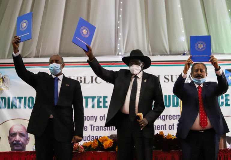 النبوءة التي قادت عبد الفتاح البرهان ليصبح رجل السودان الأقوى 3 Sudan's Sovereign Council Chief General Abdel Fattah al-Burhan, South Sudan's President Salva Kiir and Sudan's Prime Minister Abdalla Hamdok lift copies of a signed peace agreement with the country's five key rebel groups in Juba