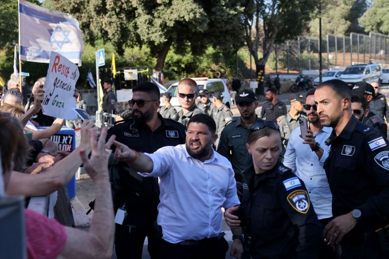 فلسطينيو 48 في مواجهة العاصفة من جديد 3 Israeli member of parliament Almog Cohen (C) argues with ativists demonstrating outside the Israeli Parliament in support of Ayman Odeh, of Israel's Arab Front for Change (Hadash), ahead of a vote to oust the Arab-Israeli lawmaker from the Knesset, on July 14, 2025. (Photo by AHMAD GHARABLI / AFP)