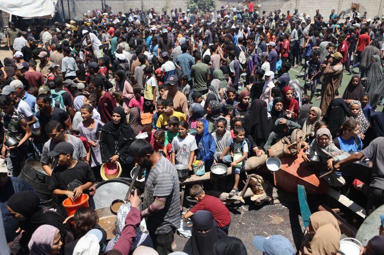 في غزة فقط يسقط الناس إغماء من الجوع ويموت الأطفال ببطء 7 Palestinians gather at a food distribution point in the Nuseirat refugee camp in the central Gaza Strip on July 19, 2025.