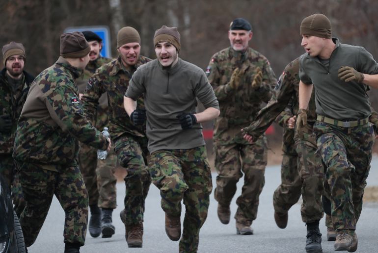 GRAFENWOEHR, GERMANY - FEBRUARY 11: Swiss military tank crew members cheer on a colleague running in a competition during the U.S. Army Europe and Africa International Tank Challenge on February 11, 2025 at Grafenwoehr, Germany. Five nations are competing in the two week competition at the U.S. 7th Army Training Command's Grafenwoehr training area in Bavaria. (Photo by Sean Gallup/Getty Images)