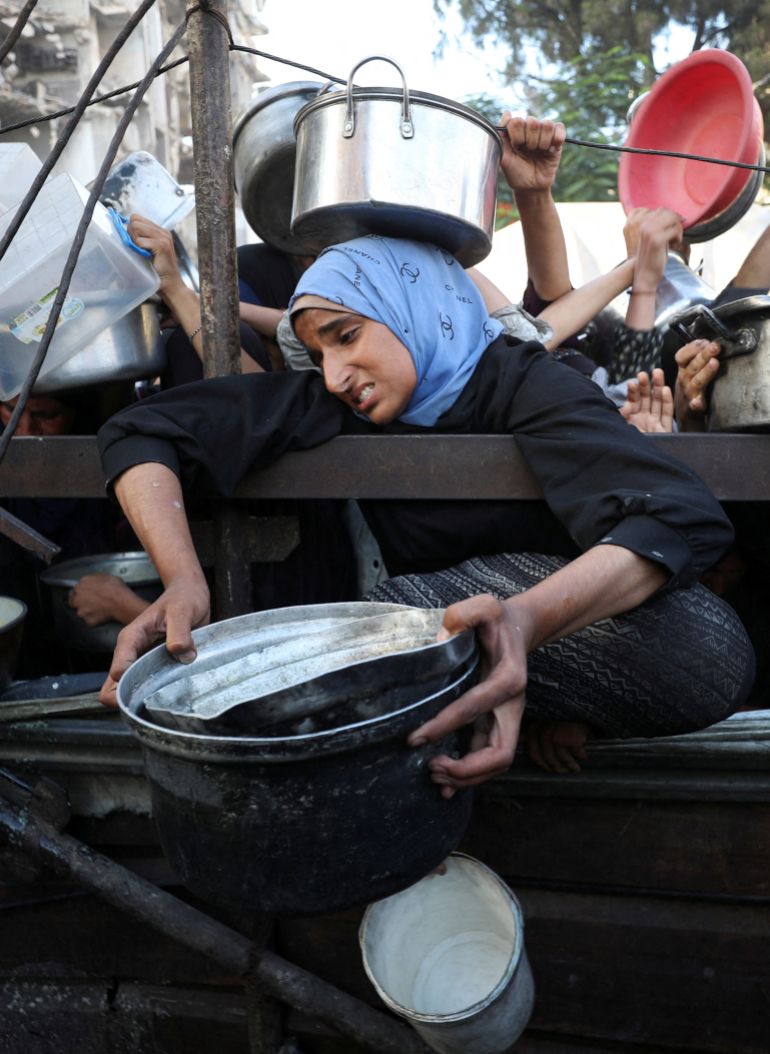 في غزة فقط يسقط الناس إغماء من الجوع ويموت الأطفال ببطء 1 A Palestinian woman reacts as she asks for food from a charity kitchen, amid a hunger crisis, in Gaza City, July 14, 2025. REUTERS/Mahmoud Issa