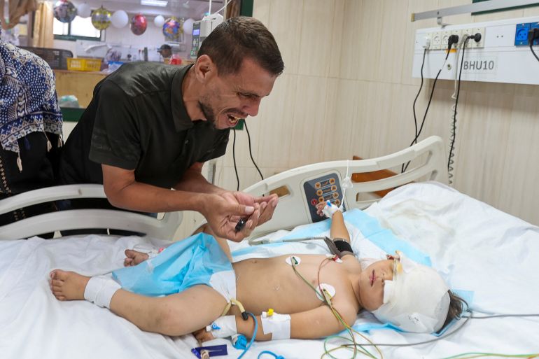 قصة عائلة غزاوية استشهد أطفالها أثناء بحثهم عن غذاء 6 Palestinian father Hatem Al-Nouri, who lost two of his children, Omar and Amir, in the July 10 Israeli strike while they were queuing for supplements near a medical center, reacts as he accompanies his son Siraj, who was wounded in the same strike, at Al-Aqsa Martyrs Hospital in Deir al-Balah, in the central Gaza Strip, July 14, 2025. REUTERS/Ramadan Abed