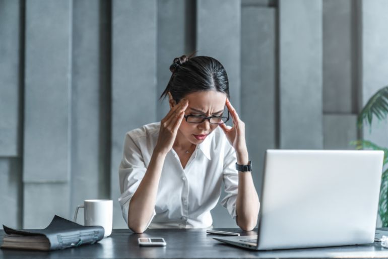 إرهاق الأخبار وتجنبها.. ما الذي عكّر مزاج جمهور وسائل الإعلام؟ 1 Young woman working on laptop having headache. Bored workaholic female accountant employee with headache and stress. Businesswoman woman with migraine, stress relief, chronic pain