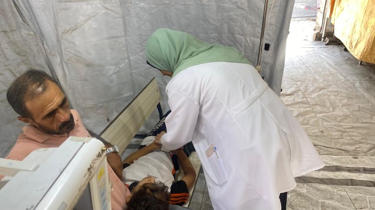 يوميات أطباء مجوّعين يعالجون مصابين بسوء التغذية بغزة 1 طبيبة تعاين طفلا مجوع يلقي برأسه على ساق والده المنهك من المجاعة-رائد موسى-دير البلح-الجزيرة نت