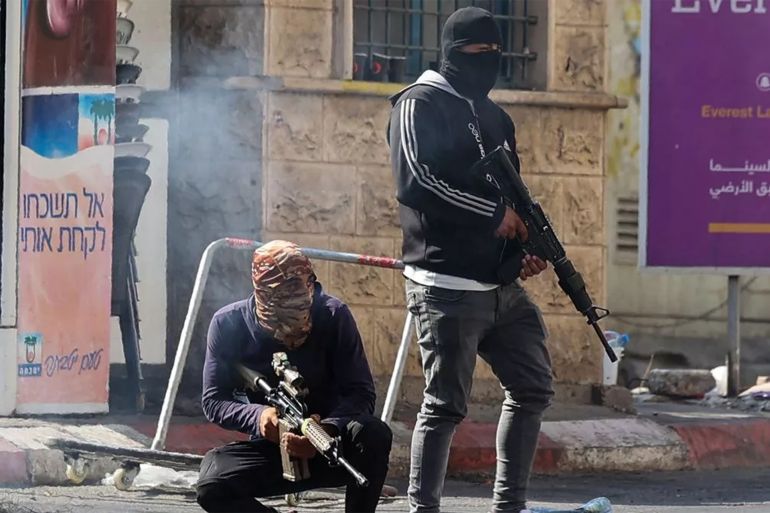كيف حوّلت إسرائيل المستوطنين لمليشيا يحميها جيش الاحتلال؟ 4 Palestinian armed militants take up position during a confrontation with Israeli army in the occupied West Bank city of Jenin on July 3, 2023. The Israeli army said it had launched drone strikes in Jenin as part of an "extensive counterterrorism effort" that the Palestinian health ministry said killed four residents. (Photo by Jaafar ASHTIYEH / AFP