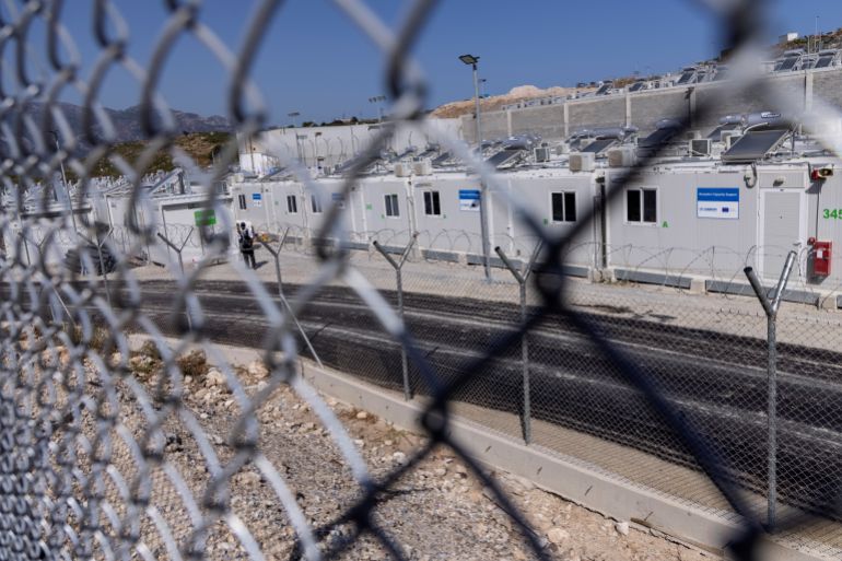 A private security employee stands guard during the inauguration of a closed-type migrant camp on the island of Samos, Greece, September 18, 2021. REUTERS/Alkis Konstantinidis