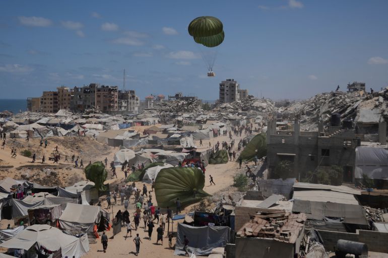 أبرز الصور في أسبوع.. غزة تحت حصار الموت ومظاهرات العالم تفضح التجويع 4 Palestinians rush to collect humanitarian aid airdropped by parachutes into Gaza City, northern Gaza Strip, Aug. 7, 2025. (AP Photo/Jehad Alshrafi)