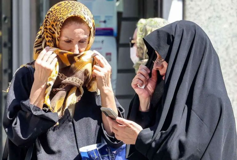 ما تداعيات تفعيل آلية الزناد على الاقتصاد الإيراني؟ 1 A woman browses a phone while standing along a street in Tehran on September 10, 2023. Iranian authorities have blocked popular social media networks, including Instagram and WhatsApp since mass protests erupted following the September 2022 death in police custody of 22-year-old Iranian Kurd Mahsa Amini. The restrictions come as millions of Iranians struggle to make ends meet, grappling with in an economic crisis marked by crippling Western sanctions, a galloping inflation, and sharp decline of the local currency. (Photo by ATTA KENARE / AFP) (Photo by ATTA KENARE/AFP via Getty Images)