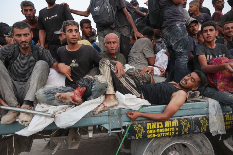 مراسلة الجزيرة نت بغزة.. قصة أم تطعم أبناءها من رماد المجاعة 1 Palestinians transport an injured man as bring back aid parcels they managed to procure west of Beit Lahia on July 29, 2025, after aid trucks entered the Israel-besieged Gaza Strip from the northern Zikim border crossing. (Photo by Omar AL-QATTAA / AFP)