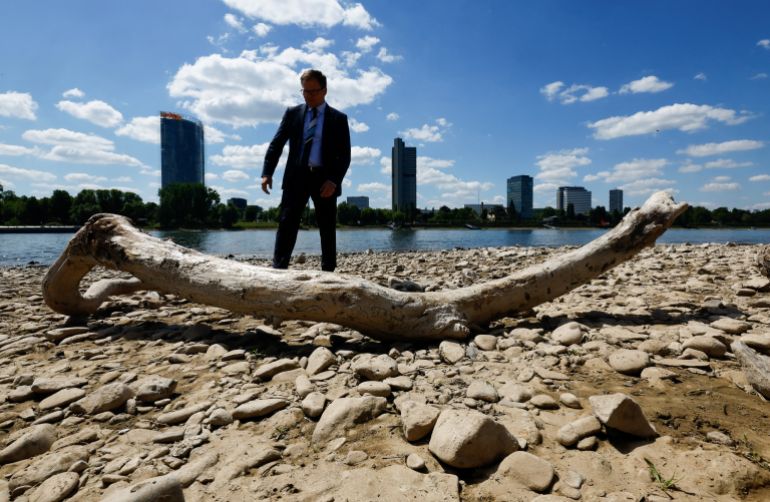 German Environment Minister Carsten Schneider looks at alluvial wood in the dry bed of Europe's most frequented waterway, the Rhine river, during his tour to inspect the drought that plagues most parts of western Germany, in Bonn, Germany, May 19, 2025. REUTERS/Wolfgang Rattay