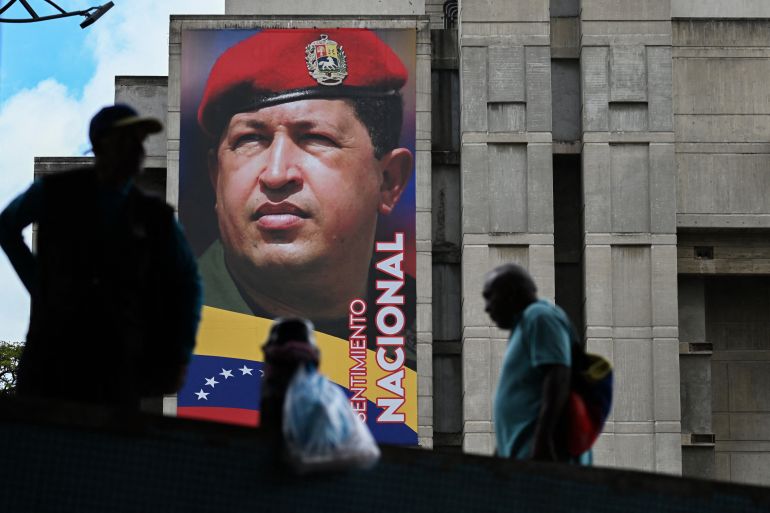 كيف نفهم التوتر بين أميركا وفنزويلا؟ وما السيناريوهات المتوقعة؟ 2 People walk past a mural of Venezuela's former President Hugo Chavez in Caracas on September 5, 2025. (Photo by Juan BARRETO / AFP)