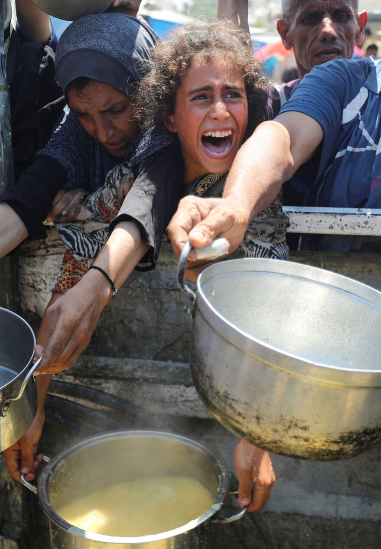 خبراء يطالبون الأمم المتحدة بمنع كارثة إنسانية أكبر بغزة 1 Palestinians react as they wait to receive food from a charity kitchen, amid a hunger crisis, in Gaza City, August 2, 2025. REUTERS/Mahmoud Issa
