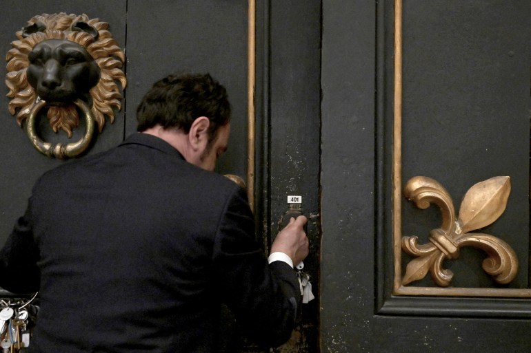 "حارس المفاتيح" في متاحف الفاتيكان.. يشرّع الأبواب فجرا قبل تدفق الزوار 1 Gianni Crea, key keeper of the Vatican Museums, open a wooden door during a private visit of the museums by night, early on February 13, 2024. (Photo by Tiziana FABI / AFP)