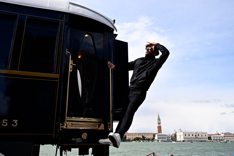 بينالي البندقية يسلط الضوء على هشاشة الكوكب وعلاقة الإنسان بالطبيعة 1 French artist JR is pictured next to a carriage-sized suite called L'Observatoire onboard the Venice Simplon-Orient-Express, in the garden of the Cipriani Hotel, on the sidelines of the Venice Biennale art show, on April 18, 2024 in Venice. (Photo by GABRIEL BOUYS / AFP) / RESTRICTED TO EDITORIAL USE - MANDATORY MENTION OF THE ARTIST UPON PUBLICATION - TO ILLUSTRATE THE EVENT AS SPECIFIED IN THE CAPTION