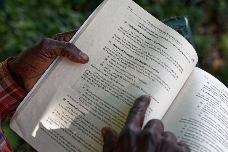 A man reads a book in Zimbabwe [File: Ben Curtis/AP]