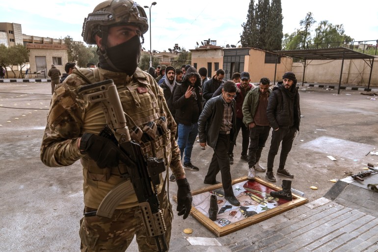 DAMASCUS, SYRIA - DECEMBER 22: Soldiers and police officers, who served in the Syrian regime army, enter the arms delivery center to surrender their weapons and ammunition with the instructions of the transitional government following the collapse of Syria's 61-year Baath regime by stepping on a table with the picture of Bashar Assad in Damascus, Syria on December 22, 2024. Life began to return to normal in Syria after the collapse of the 61-year Baath regime and the 53-year Assad family rule. ( Emin Sansar - Anadolu Agency ) (Anadolu)