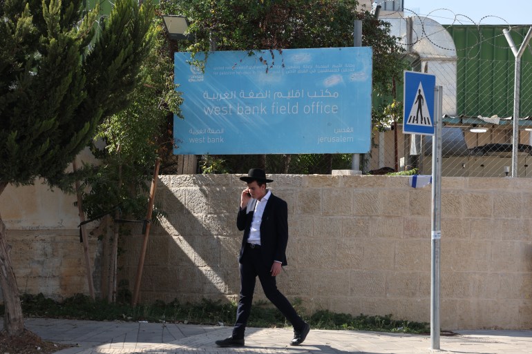 epa11690220 A man walks past the United Nations Relief and Works Agency for Palestine Refugees in the Near East (UNRWA) offices in Jerusalem, 29 October 2024. During the opening session of the winter legislative session of the Knesset, the Israeli parliament, lawmakers passed a law that prohibits the UN Palestinian refugee agency UNRWA from operating in Israeli territory. Israel has claimed that a number of UNRWA workers have been involved in the 07 October 2023 Hamas-led attack on Israel. UNRWA Commissioner-General Philippe Lazzarini said that the Knesset vote against UNRWA was 'unprecedented' and 'sets a dangerous precedent', adding that it 'opposes' the UN Charter and 'violates' the State of Israel's obligations under international law. EPA-EFE/ABIR SULTAN