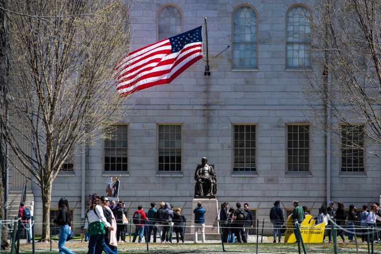 كيف تنجو هارفارد وجامعات أميركية من تخفيض ترامب تمويلها؟ 20 (FILES) Demonstrators with signs stand around the John Harvard Statue in Harvard Yard following a rally against President Donald Trump’s attacks on Harvard University at Harvard University in Cambridge, Massachusetts on April 17, 2025.