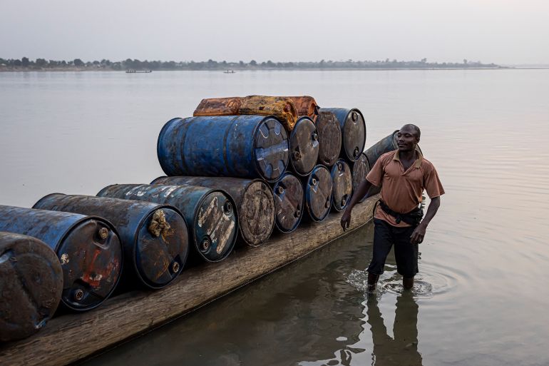 غاز ورشاوى وصمت مدو.. حين فتحت الكونغو أبواب أفريقيا أمام "إيني" الإيطالية 20 A man stands next to a pirogue full of empty barrels headed for the Democratic Republic of Congo (DRC) to collect palm oil in Bangui, on February 27, 2025. (Photo by PATRICK MEINHARDT / AFP)