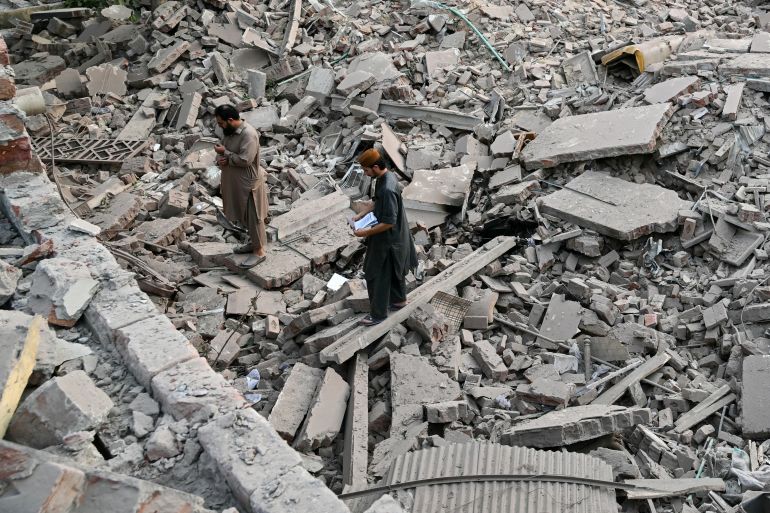 هل أنقذت إدارة ترامب العالم من كارثة نووية بين الهند وباكستان؟ 19 Locals stand on the debris of destroyed structures at the Government Health and Educational complex in Muridke about 30 kilometres from Lahore, on May 7, 2025, after Indian strikes. The death toll from Indian strikes on Pakistan has increased to eight, the country's military spokesman said on May 7, as India fired missiles at Pakistani territory and Islamabad vowed to "settle the score". (Photo by FAROOQ NAEEM / AFP)
