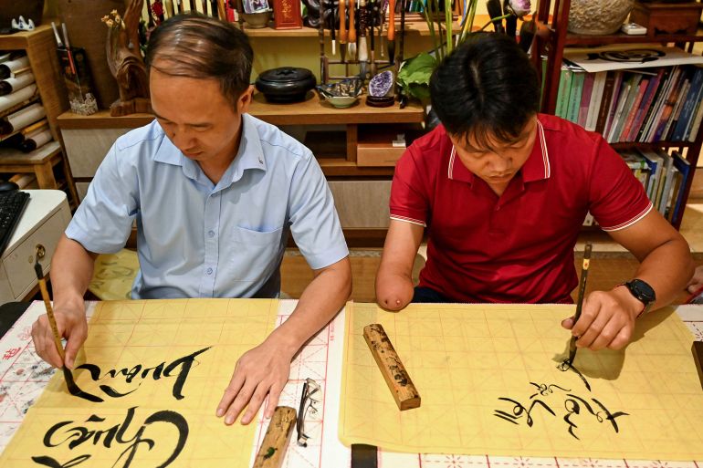 الكتابة بالأحرف اللاتينية موروث استعماري متجذر لدى الفيتناميين 3 This photo taken on May 15, 2025 shows students learning calligraphy at the home of calligrapher Nguyen Thanh Tung in Hanoi. At a calligraphy class in Hanoi, Hoang Thi Thanh Huyen slides her brush across the page to form the letters and tonal marks of Vietnam's unique modern script, in part a legacy of French colonial rule. (Photo by Nhac NGUYEN / AFP) / TO GO WITH VIETNAM-FRANCE-ALPHABET-DIPLOMACY-MACRON, FOCUS