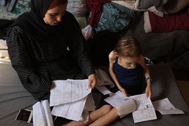 أجساد هزيلة وأعين غائرة.. أطفال غزة أول ضحايا المجاعة 21 Shuruq Ayyad and her 12-year-old daughter Rahaf, who is suffering from malnutrition, look at medical reports at a school-turned-shelter in al-Rimal in central Gaza City on May 4, 2025.