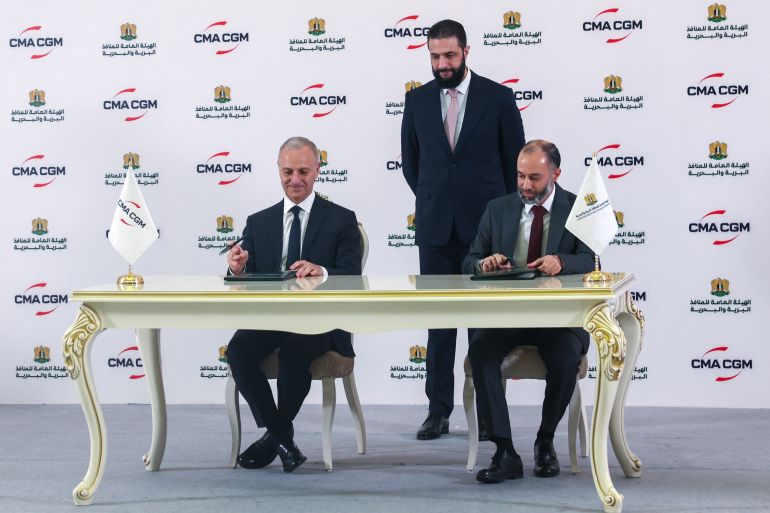بوادر انفتاح أميركي على سوريا وسط ترقب لزيارة ترامب للمنطقة 19 Syrian President Ahmed al-Sharaa (C) looks on as Joseph Dakak, the regional director of French shipping company CMA GGM, (L) and Latakia port director Ahmed Mustafa sign an agreement in Damascus on May 1, 2025.