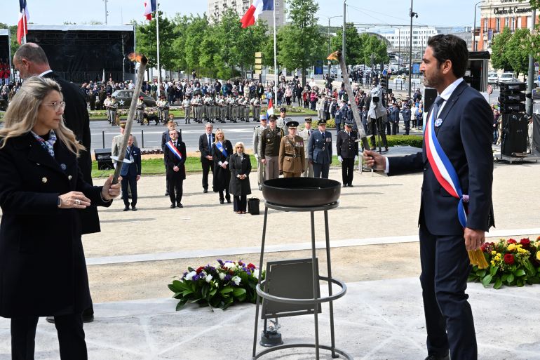بالصور.. روسيا وأوروبا تحييان ذكرى الانتصار على النازية 33 France's Delegate Minister to Memory and Veterans Affairs Patricia Miralles (L) and Reims mayor Arnaud Robinet light the flame of remembrance during the Commemoration of the 80th anniversary of the end of World War II in Europe, in Reims, north eastern France, where Nazi Germany signed its initial 1945 surrender, on May 7, 2025.