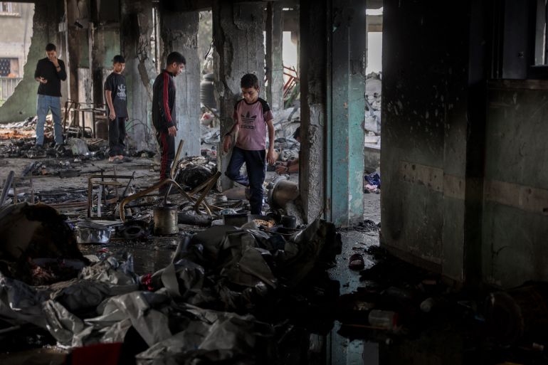 إسرائيل أحرقت النازحين نياما في مجزرة حي الدرج 22 Palestinian youths look for salvageable items amid the debris after an Israeli airstrike hit the Mussa bin Nusseir UNRWA school, serving as a shelter for people who left their homes in the besieged Palestinian territory, in Gaza City's Daraj district on May 20, 2025.