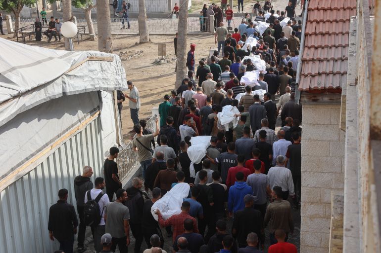 إسرائيل أحرقت النازحين نياما في مجزرة حي الدرج 24 Palestinian mourners walk in the funeral procession of relatives killed in an Israeli airstrike that hit an UNRWA school, serving as a shelter for people who left their homes in the besieged Palestinian territory, on the grounds of Gaza City's Al-Ahli Arab hospital, also known as the Baptist hospital, on May 20, 2025.