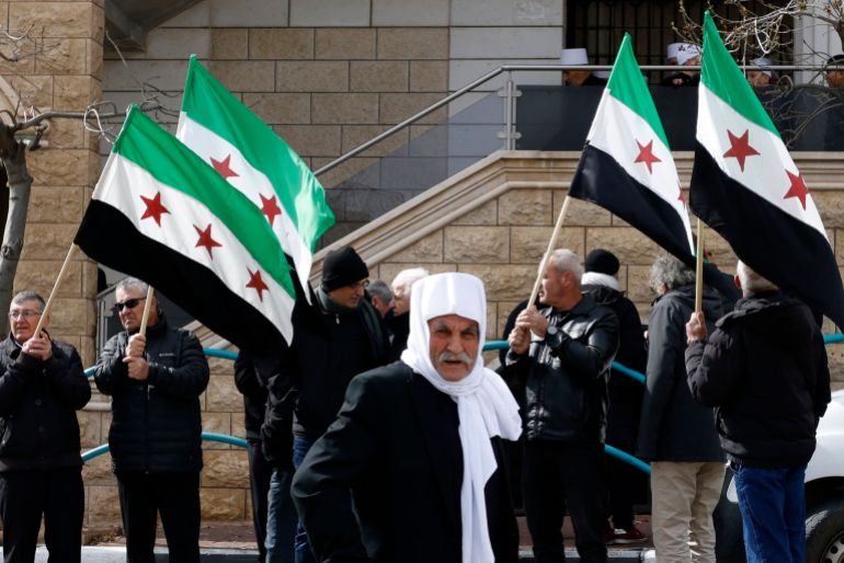 ما علاقة إسرائيل بالأقليات في سوريا؟ 20 Druze residents of the village of Majdal Shams in the Israeli-annexed Golan Heights wave Syrian flags as they take part in a rally on February 14, 2025, to protest against the 1981 annexation law of the strategic plateau which Israel captured from Syria during the 1967 Arab-Israeli war. (Photo by Jalaa MAREY / AFP)