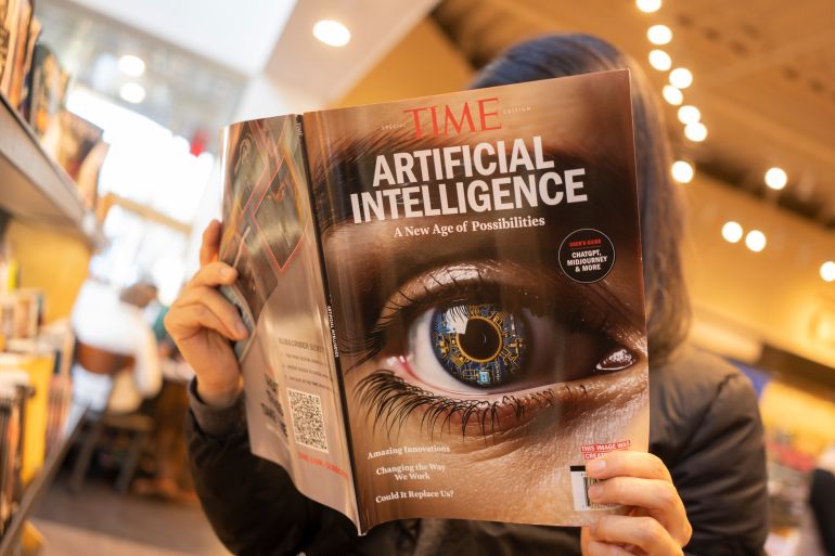 كيف يغير الذكاء الاصطناعي بيئة العمل الصحفي؟ 2 Tigard, OR, USA - Dec 12, 2023: A woman browses a TIME magazine special edition on "Artificial Intelligence: An Age of Possibilities" in a Barnes and Noble bookstore in Tigard, Oregon.