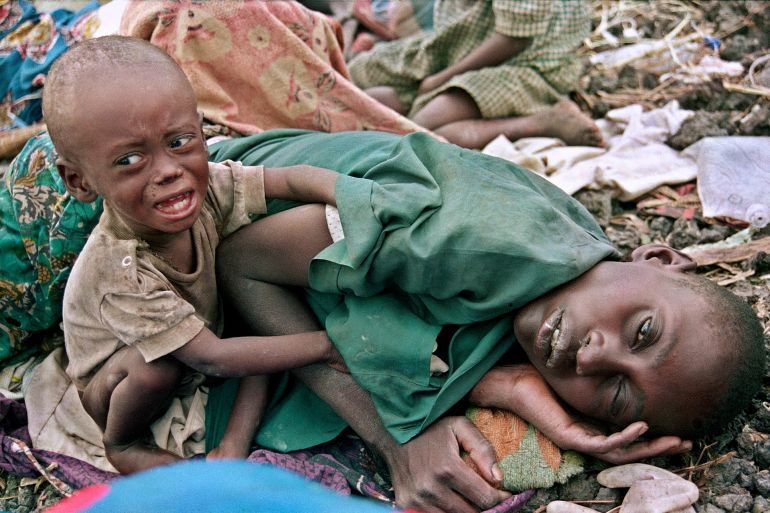 مليون قتيل بـ100 يوم.. رواندا التي عامت على بحور من الدم 5 ** FILE ** In this July 27, 1994 file photo, a Rwandan Hutu child desperately tries to awake his mother from a diseased sleep in the Munigi camp, outside Goma, Zaire. Goma, the capital of Congo's North Kivu province, is a beleaguered place in an impoverished and war-ravaged country. But this city of 500,000 always seems to carry on through the destruction, displaying the sheer grit that sustains so many people across the world's poorest continent. (AP Photo/Javier Bauluz, File)