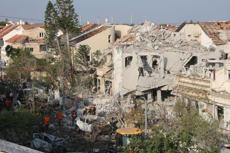 بالصور.. دمار "غير مسبوق" في إسرائيل بعد ضربات إيران 7 Israeli emergency responders inspect a site hit by a missile fired from Iran near Tel Aviv on June 14, 2025.