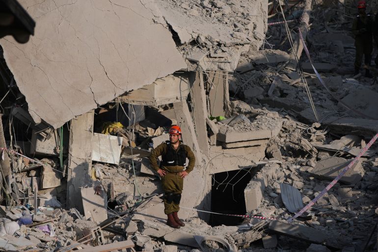 ضربة إيرانية مباشرة في ريشون ليتسيون تثير صدمة في إسرائيل 5 Israeli security forces inspect destroyed houses that were struck by a missile fired from Iran, in Rishon Lezion, Israel on Saturday, June 14, 2025. (AP Photo/Ohad Zwigenberg)