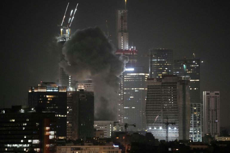 بالصور.. دمار "غير مسبوق" في إسرائيل بعد ضربات إيران 11 Smoke billows after a projectile hit a building in Tel Aviv, Israel, early Saturday, June 14, 2025. (AP Photo/Leo Correa)