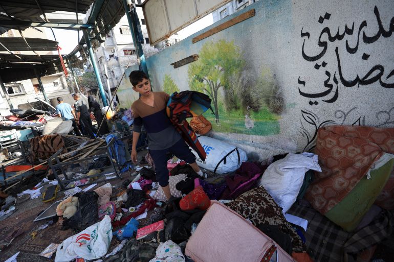 أنا بنت من غزة لم أجتز التوجيهي ودفتر أحلامي تحت الأنقاض 2 A Palestinian inspects the damage at a school sheltering displaced people, near a wall reading, "my school is my civilization", following an Israeli strike, in Gaza City, May 26, 2025. REUTERS/Dawoud Abu Alkas