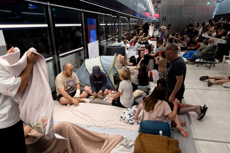 إيران تطلق الموجة الصاروخية 13 وإسرائيل تهاجم طهران 1 RAMAT GAN, ISRAEL - JUNE 18: People take cover in an underground train station transformed into a public shelter following reports of an incoming missile fired from Iran, on June 18, 2025 in Ramat Gan, Israel. Iran launched a retaliatory missile strike on Israel starting late on June 13, after a series of Israeli airstrikes earlier in the day targeted Iranian military and nuclear sites, as well as top military officials. (Photo by Amir Levy/Getty Images)