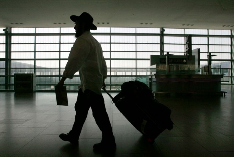 الفرار من حيفا وتل أبيب: الهجرة العكسية تُربك الدولة العِبرية 1 A lone traveller walks with his luggage through Ben-Gurion international airport near Tel Aviv March 21, 2007. Israel's powerful Histadrut labour union launched a general strike on Wednesday, stopping international flights and shutting public services after talks with the government broke down. The open-ended strike began at 9 a.m. (0700 GMT) but a labour court was due to convene to discuss a government petition for a restraining order to restore services. Israel Radio said the court was expected to rule within hours. REUTERS/Yonathan Weitzman (ISRAEL)
