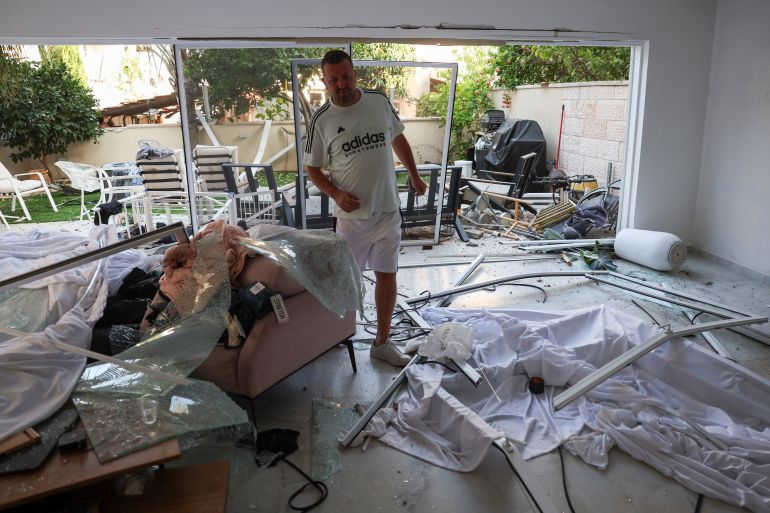 ضربة إيرانية مباشرة في ريشون ليتسيون تثير صدمة في إسرائيل 4 A man walks inside a damaged house at an impact site following missile attack from Iran on Israel, in Rishon LeZion, Israel, June 14, 2025. REUTERS/Ronen Zvulun