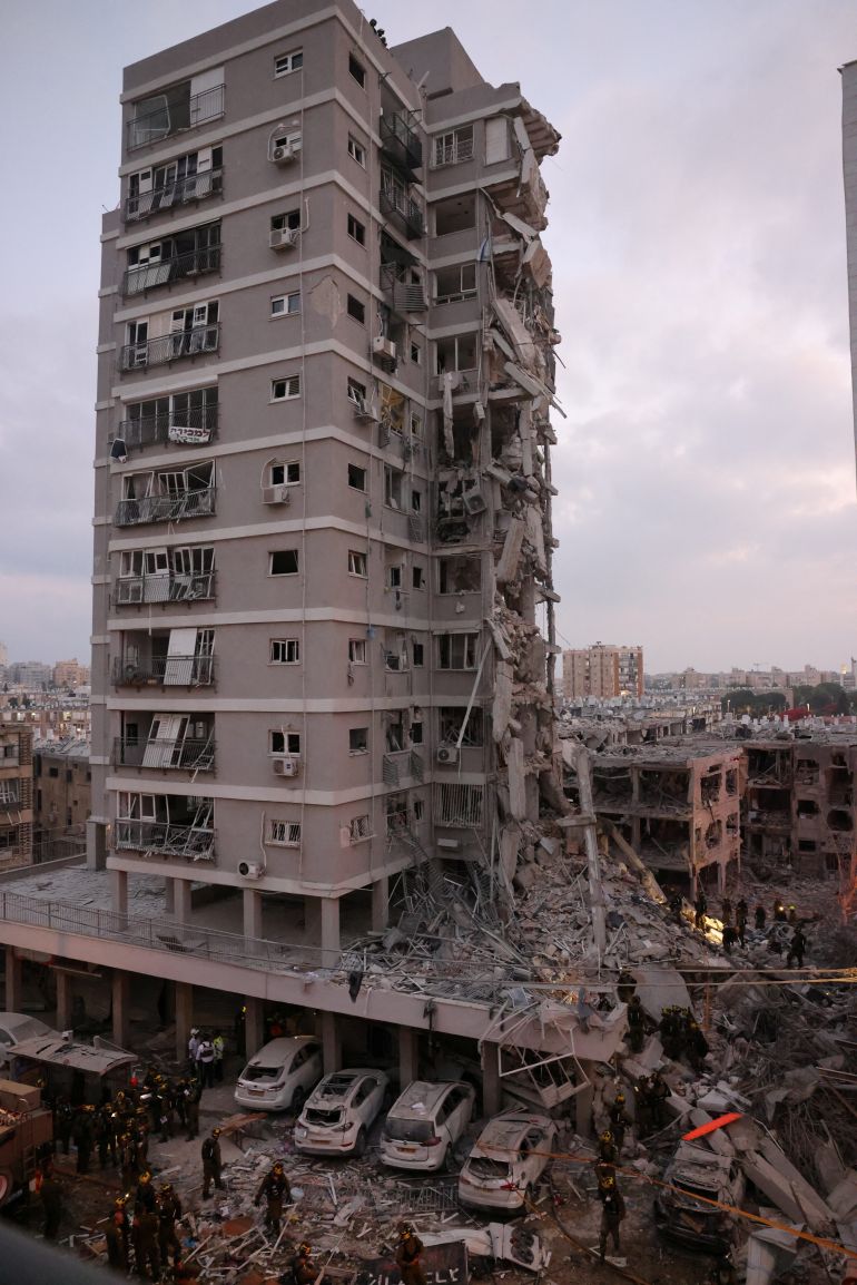 قتلى وجرحى ودمار كبير بعد هجوم صاروخي إيراني على إسرائيل 1 People stand near a residential building that was hit following missile attack from Iran on Israel, at central Israel June 15, 2025. REUTERS/Tomer Appelbaum ISRAEL OUT. NO COMMERCIAL OR EDITORIAL SALES IN ISRAEL