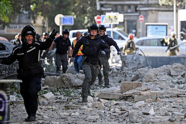 ذا هيل: 5 نقاط بارزة بعد دخول الولايات المتحدة حربا مع إيران 1 Security forces run as a second siren sounds at an impacted site, as they work following an earlier missile attack from Iran, amid the Iran-Israel conflict in Haifa, Israel June 22, 2025. REUTERS/Rami Shlush ISRAEL OUT. NO COMMERCIAL OR EDITORIAL SALES IN ISRAEL.