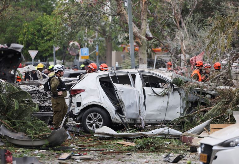 ضربة إيرانية مباشرة في ريشون ليتسيون تثير صدمة في إسرائيل 1 Rescue personnel stand next to damaged vehicles as they work at an impact site following missile attack from Iran on Israel, in Rishon LeZion, Israel, June 14, 2025. REUTERS/Ronen Zvulun
