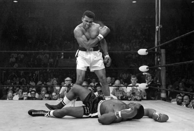 حفيد أسطورة الملاكمة محمد علي: جدي خاض نزالات وهو مريض بـ"باركنسون" 5 Heavyweight champion Muhammad Ali stands over fallen challenger Sonny Liston, shouting and gesturing shortly after dropping Liston with a short hard right to the jaw on May 25, 1965, in Lewiston, Maine. The bout lasted only one minute into the first round. Ali is the only man ever to win the world heavyweight boxing championship three times. He also won a gold medal in the light-heavyweight division at the 1960 Summer Olympic Games in Rome as a member of the U.S. Olympic boxing team. In 1964 he dropped the name Cassius Clay and adopted the Muslim name Muhammad Ali. (AP Photo/John Rooney)