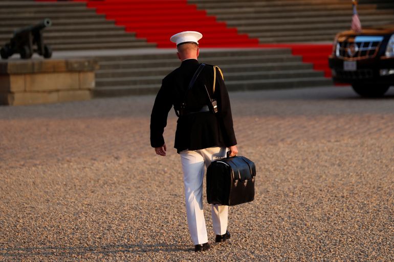 اللحظة صفر.. نهاية العالم من داخل حقيبة جلدية 1 A military aide carries the "football" containing launch codes for nuclear weapons into Blenheim Palace, where U.S. President Donald Trump and first lady Melania Trump were dining, in Woodstock, Britain, July 12, 2018. REUTERS/Kevin Lamarque