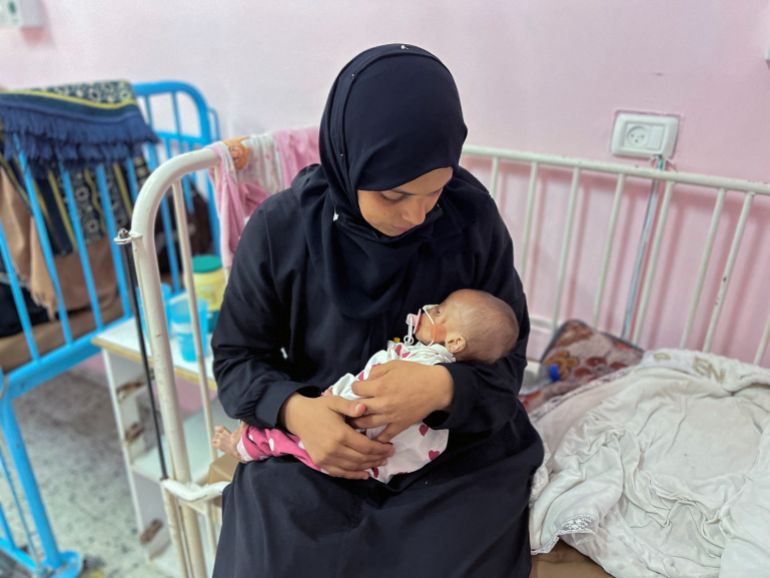 فاطمة تحارب الجوع في غزة لتنقذ جنينها 6 Palestinian mother Israa Abu Haleeb looks after her five-month-old daughter, Zainab, who is diagnosed with malnutrition, according to medics, at Nasser hospital in Khan Younis, in the southern Gaza Strip July 15, 2025. REUTERS/Hussam Al-Masri TPX IMAGES OF THE DAY