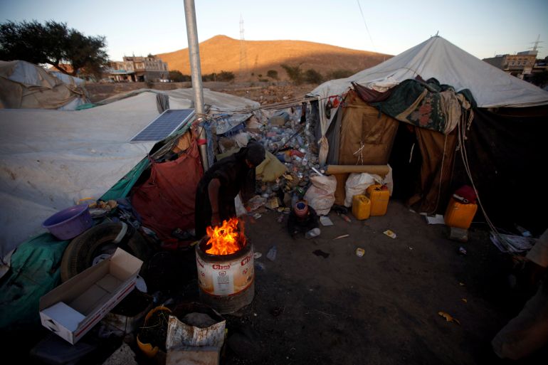 نازحون منسيون باليمن يروون لغادريان معاناتهم من الجوع 1 A displaced Yemeni woman ligths a fire in a makeshift camp near Sanaa, Yemen November 17, 2017. REUTERS/Mohamed al-Sayaghi
